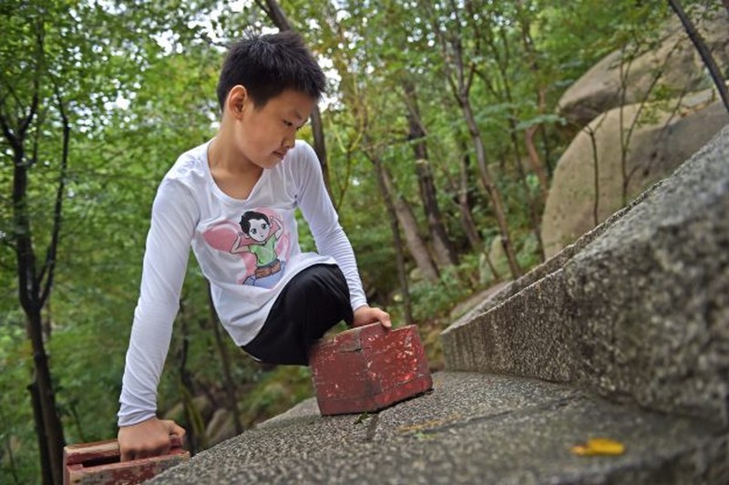 Wanderlust Tips Magazine | 11-year-old legless boy conquered 900m high moutain in China