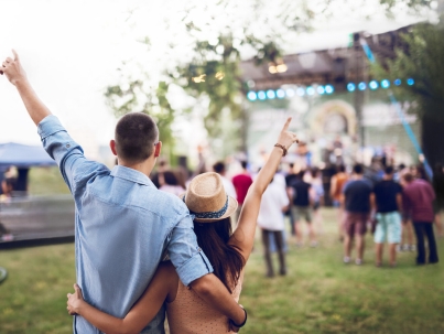 Young Caucasian couple toasting on a music festival.